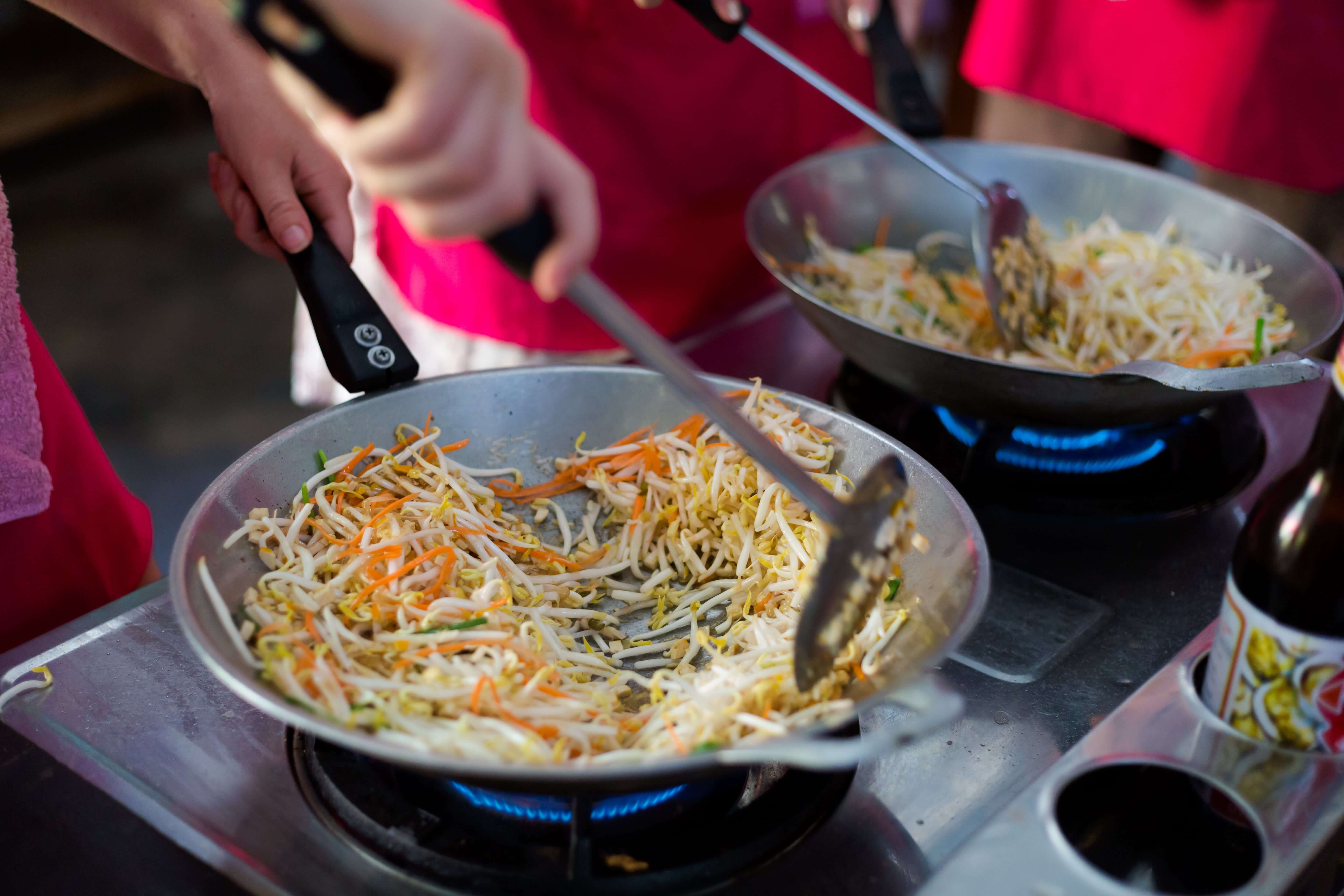 Cooking spring rolls stuffing in wok frying pan. Bangkok, Thailand